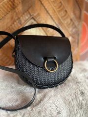 Black stamped leather bag with antique brass oring doorknocker closure on faux fur