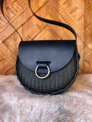 Black stamped leather bag with antique nickel oring doorknocker closure on faux fur