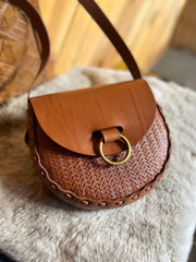 Tan stamped leather bag with antique brass oring doorknocker closure on faux fur