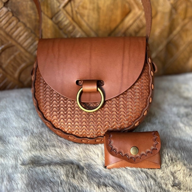 Tan stamped leather bag with matching snap wallet on faux fur