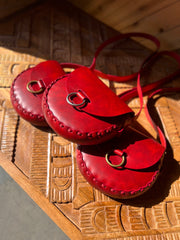 Trio of crimson red leather bags hand carved wooden table